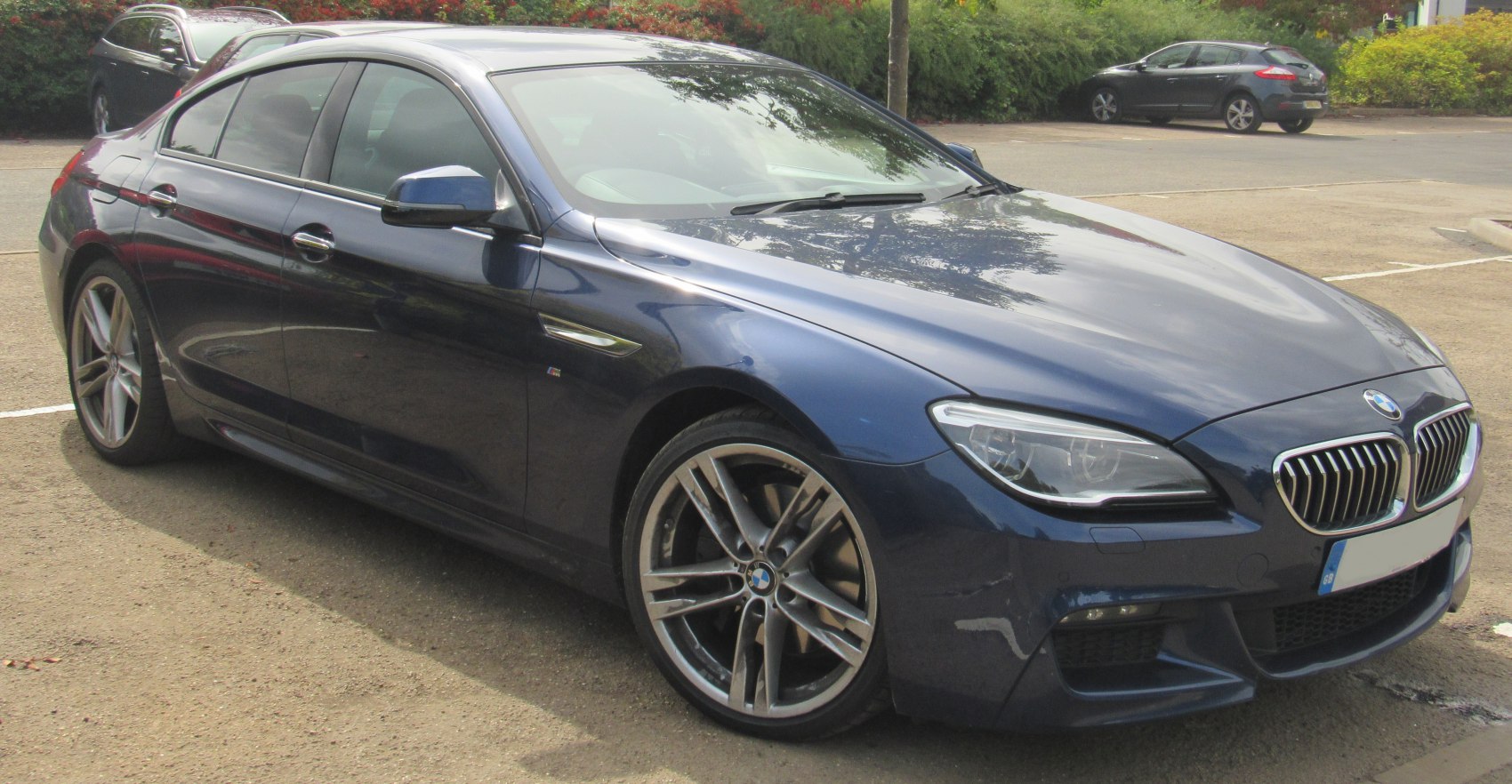 Front side view of a luxury sedan with alloy wheels.