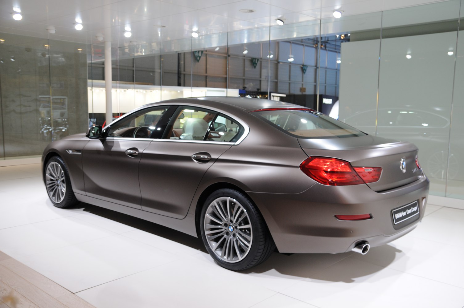 Side and rear view of a luxury four-door coupe with distinctive taillights and alloy wheels