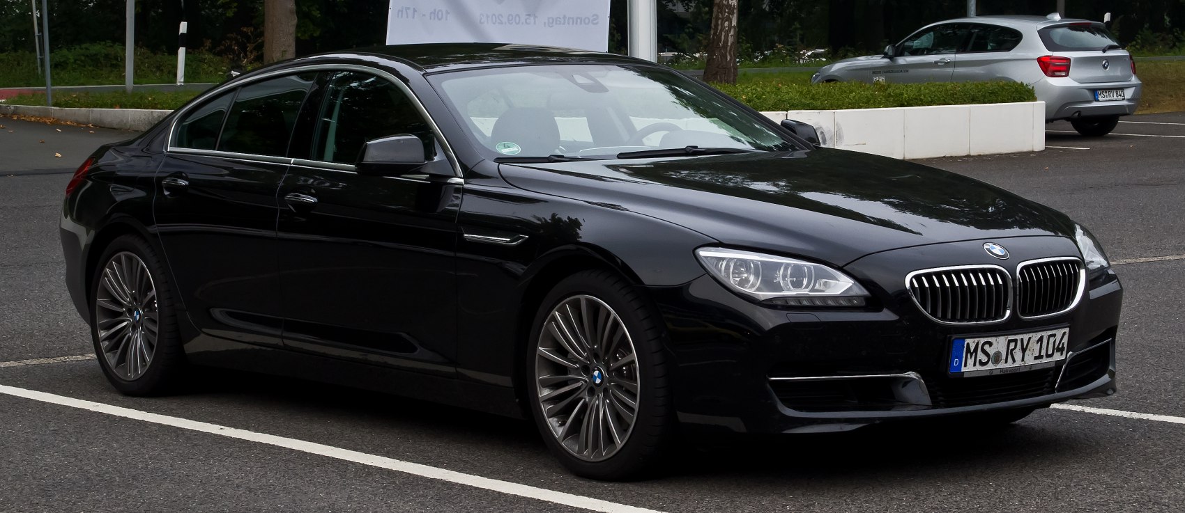 Front-side view of sleek luxury sedan with distinctive headlights and alloy wheels