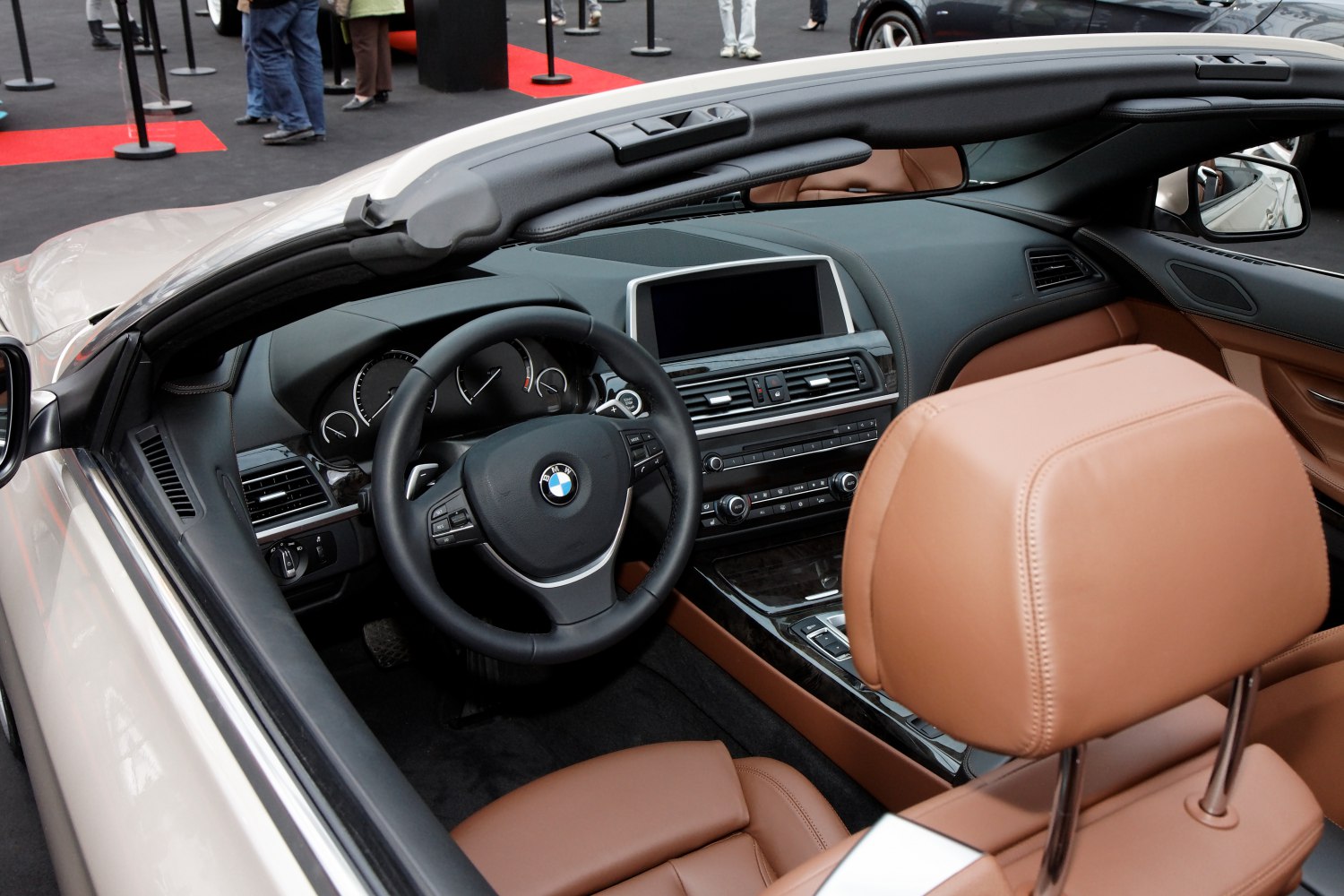 Dashboard and steering wheel of convertible car with brown leather seats