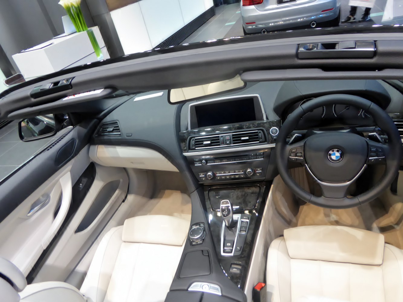 Luxury convertible interior with dashboard, steering wheel, and infotainment system