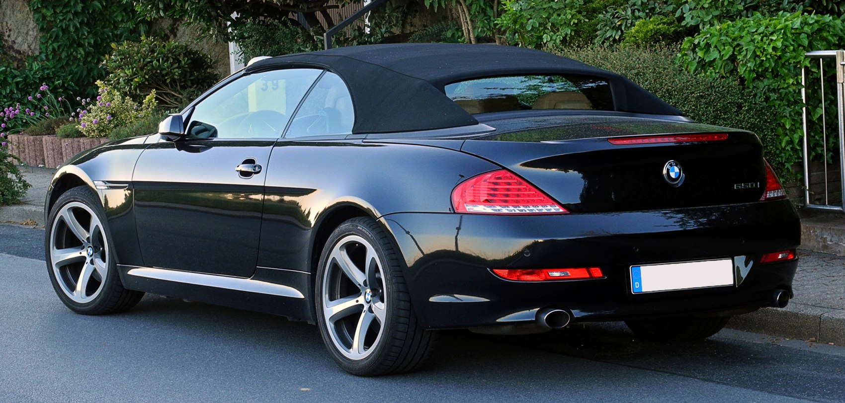Rear view of convertible with black soft top and alloy wheels