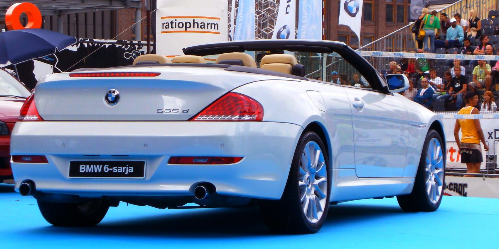 Rear view of white convertible showcasing taillights and dual exhausts