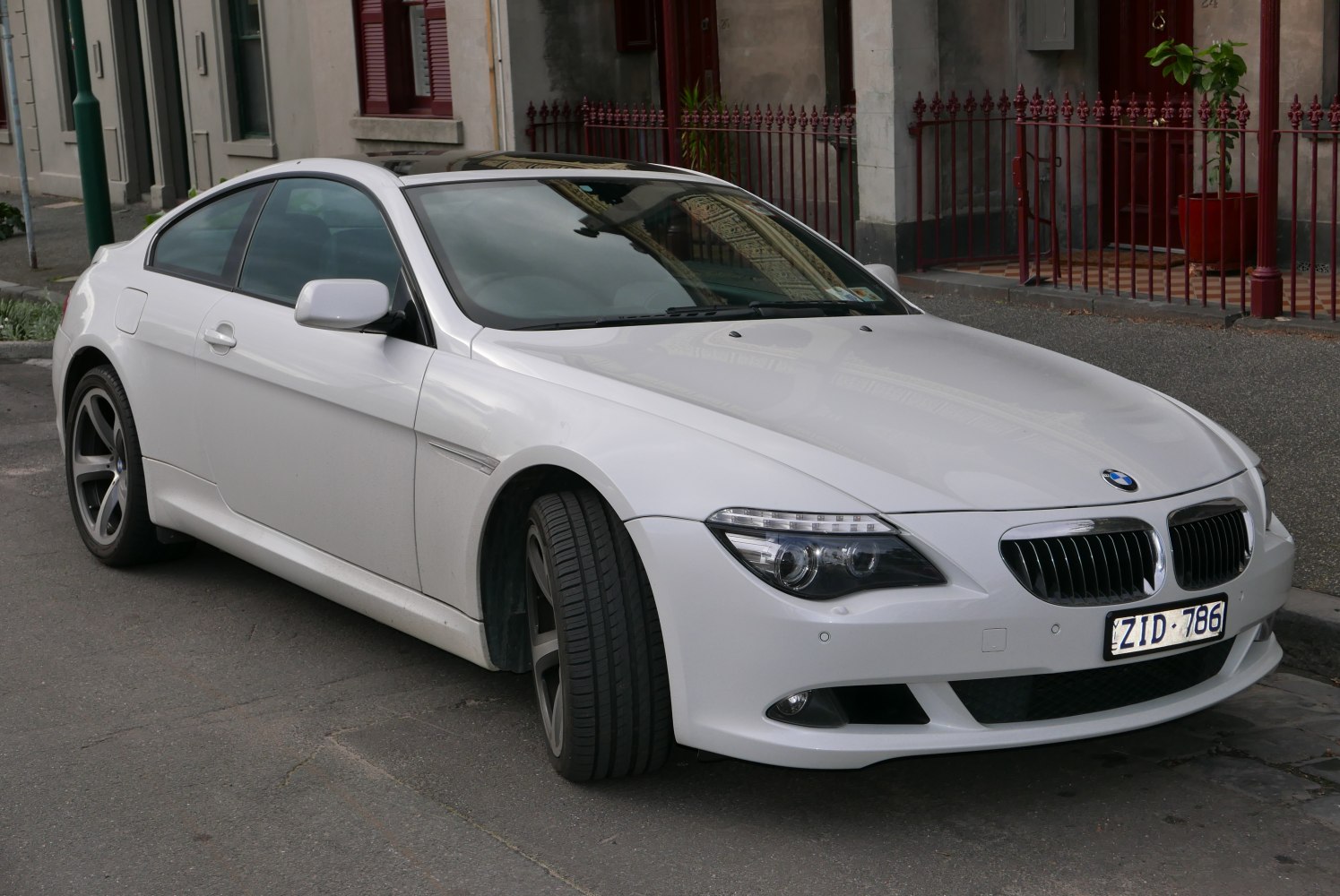 White luxury coupe front side with distinctive kidney grille and sharp headlights