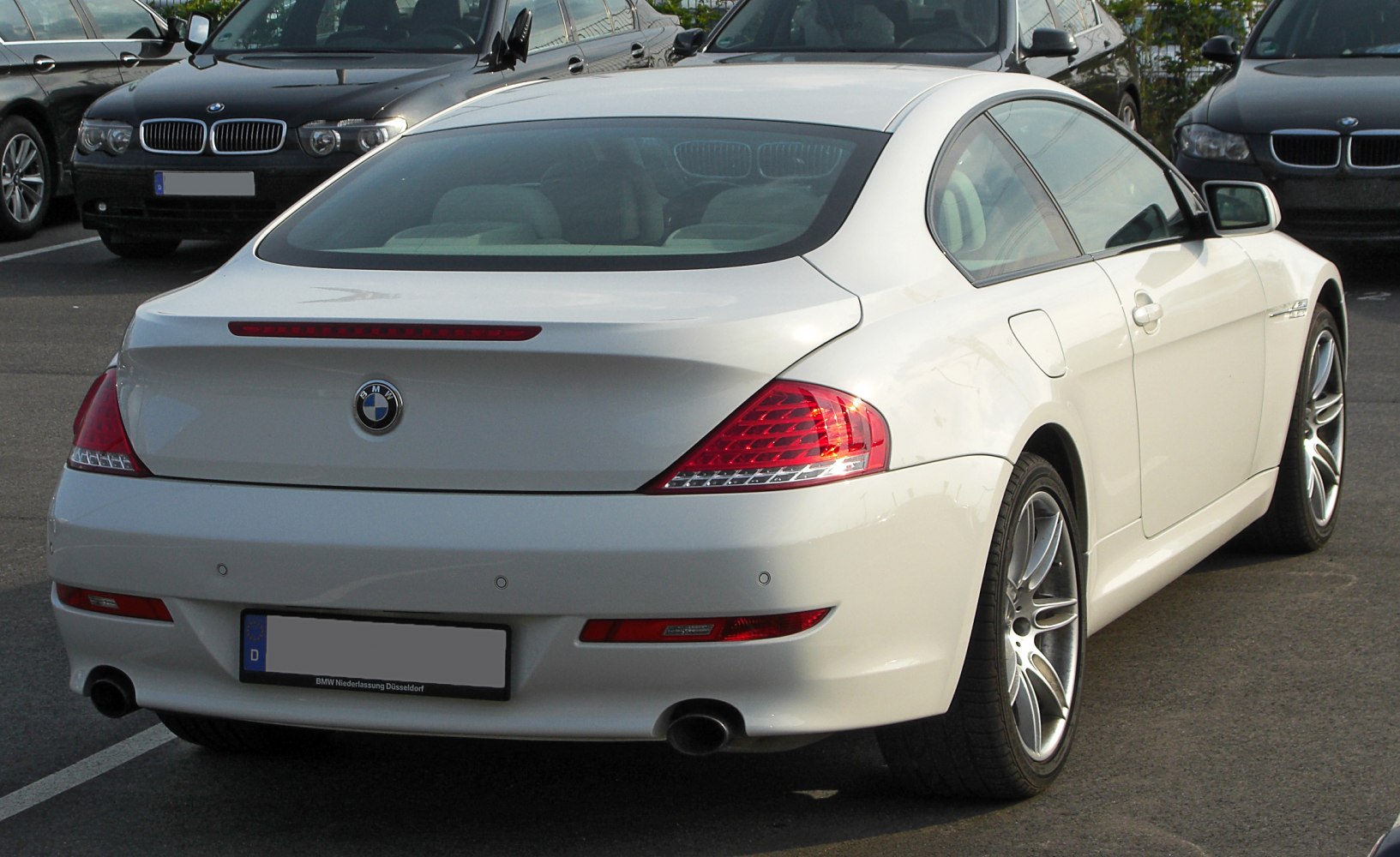 Rear view with LED taillights, dual exhaust, and sleek coupe design