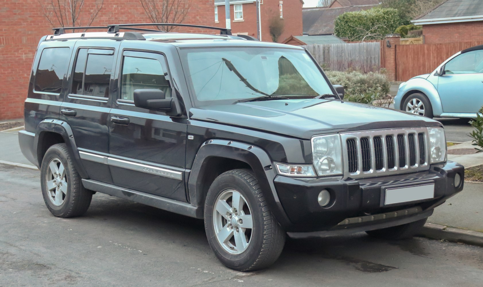 Boxy SUV front side view with seven-slot grille and roof rails