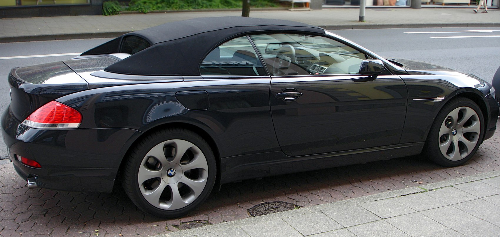 Side view of a convertible with closed soft fabric roof and alloy wheels