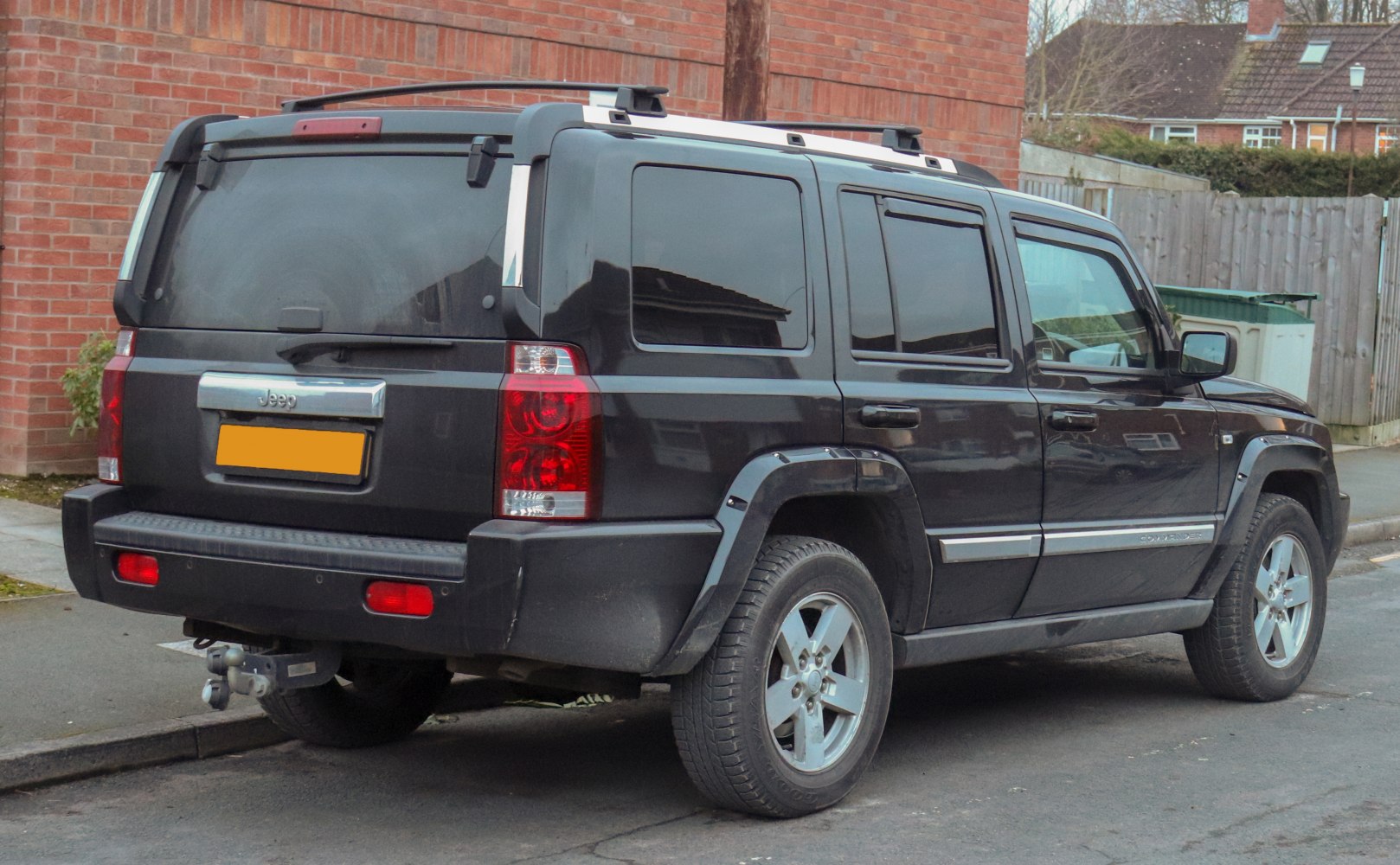 Rear and side view of black SUV with tinted windows and trailer hitch
