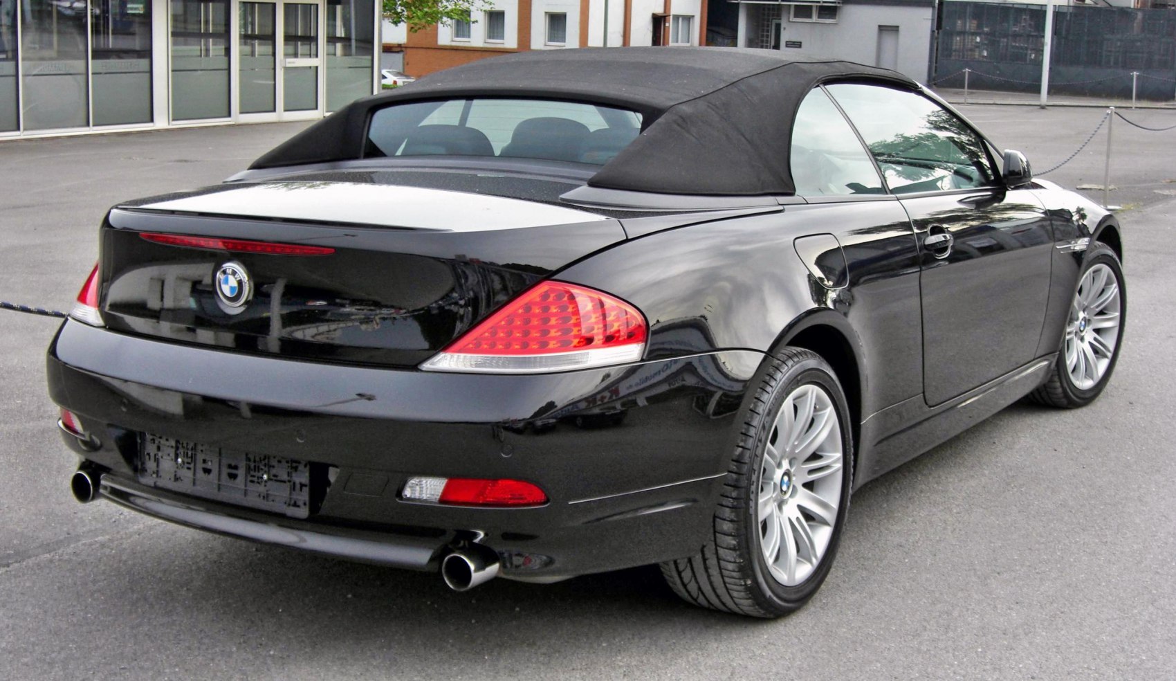 Rear view of convertible with soft fabric roof and dual exhaust.