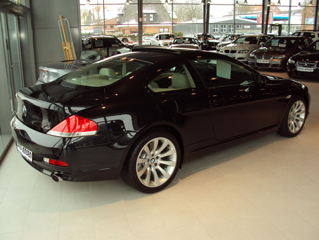 Rear and side profile of a black coupe with alloy wheels