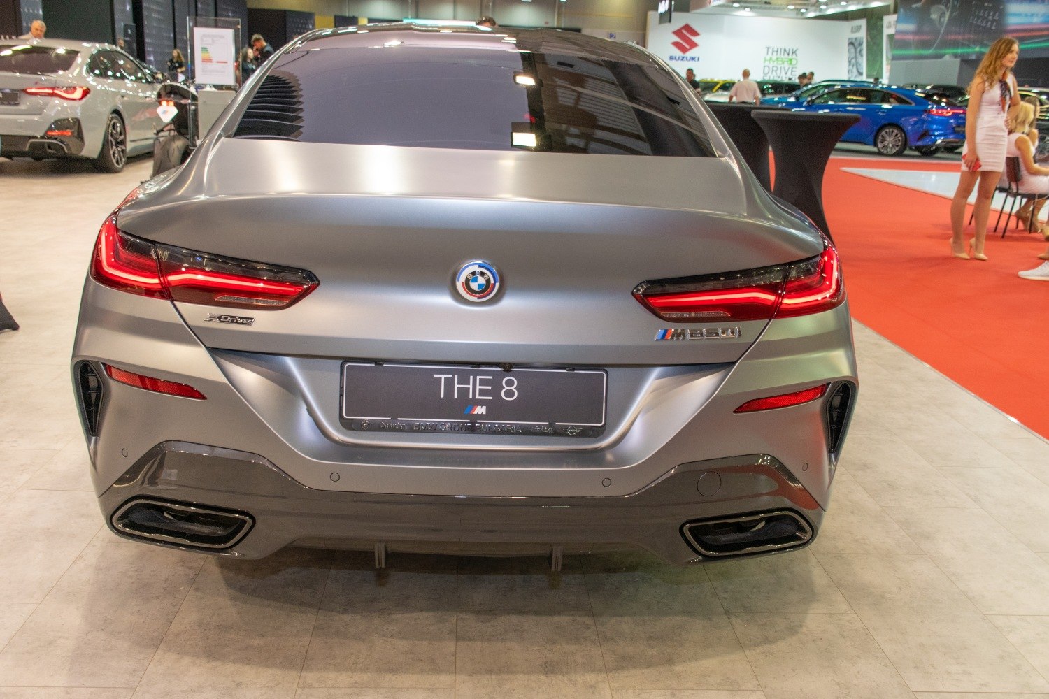 Rear view of matte gray car with LED tail lights and dual exhaust