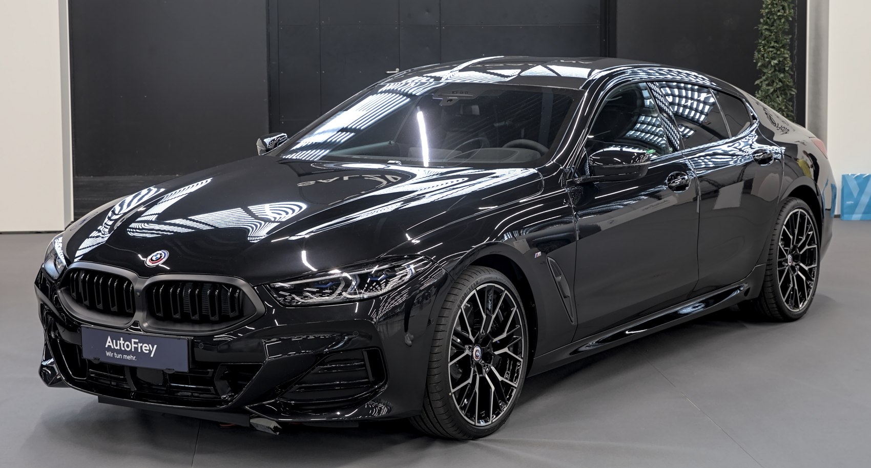 Front side view of a sleek black 4-door luxury sports sedan with sporty grille and alloy wheels.