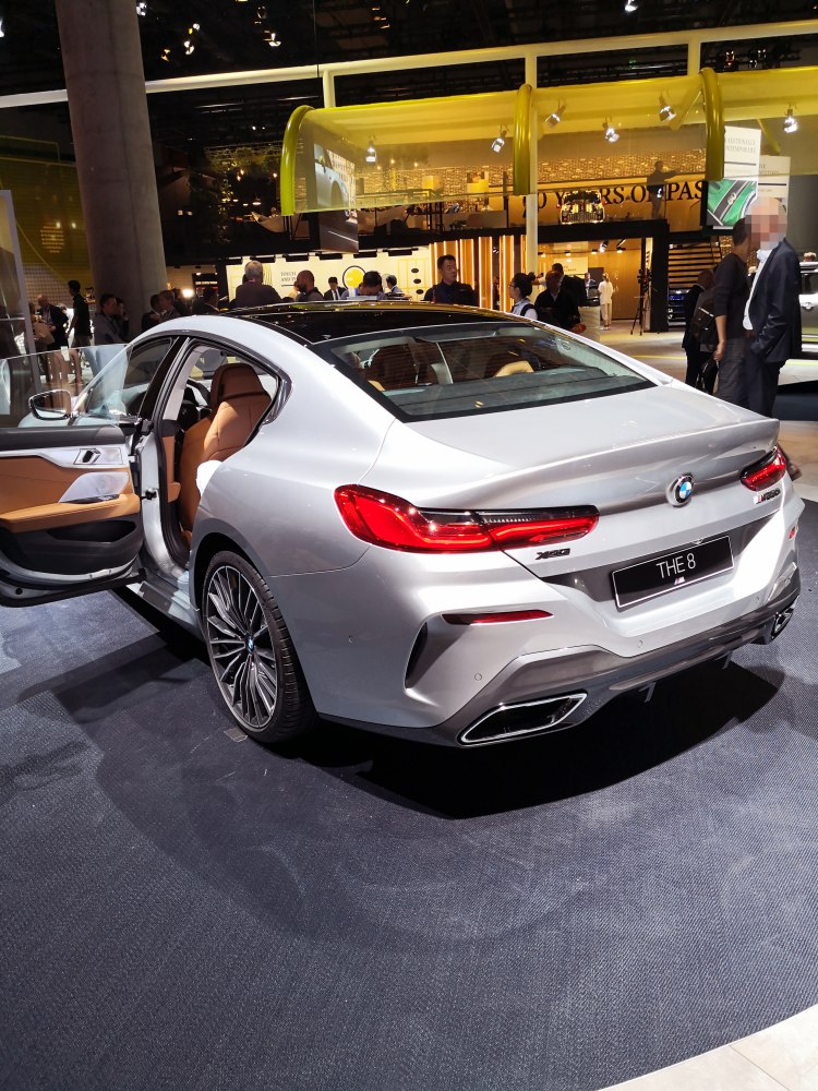 Rear view of luxury sedan with open door revealing tan leather interior