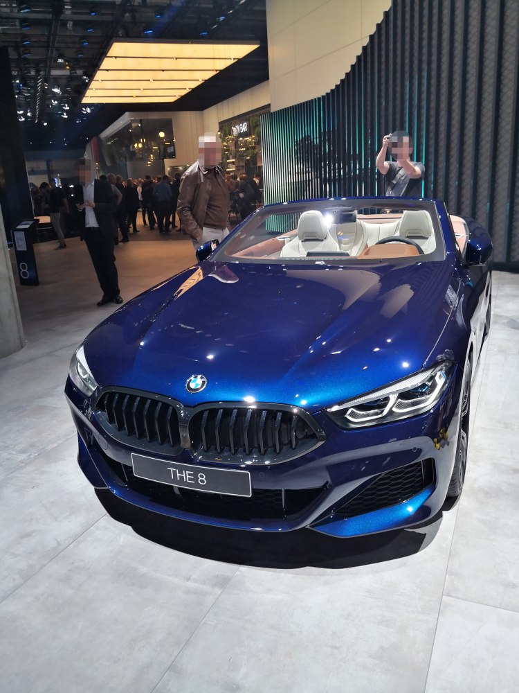 Front view of blue convertible with distinct grill and white interior