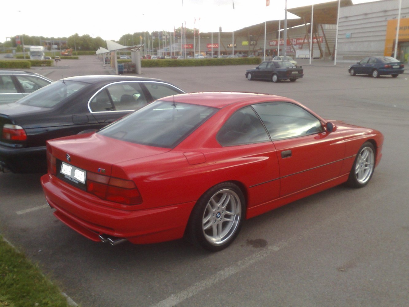 Red coupe with sleek rear design and distinctive alloy wheels