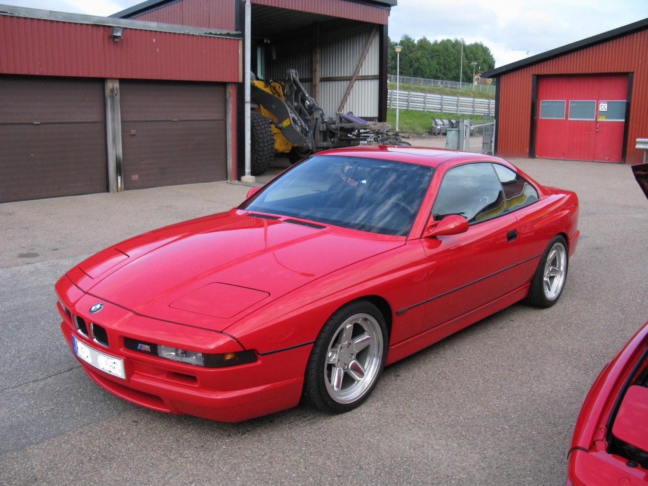 Red sports coupe with pop-up headlights and alloy wheels.
