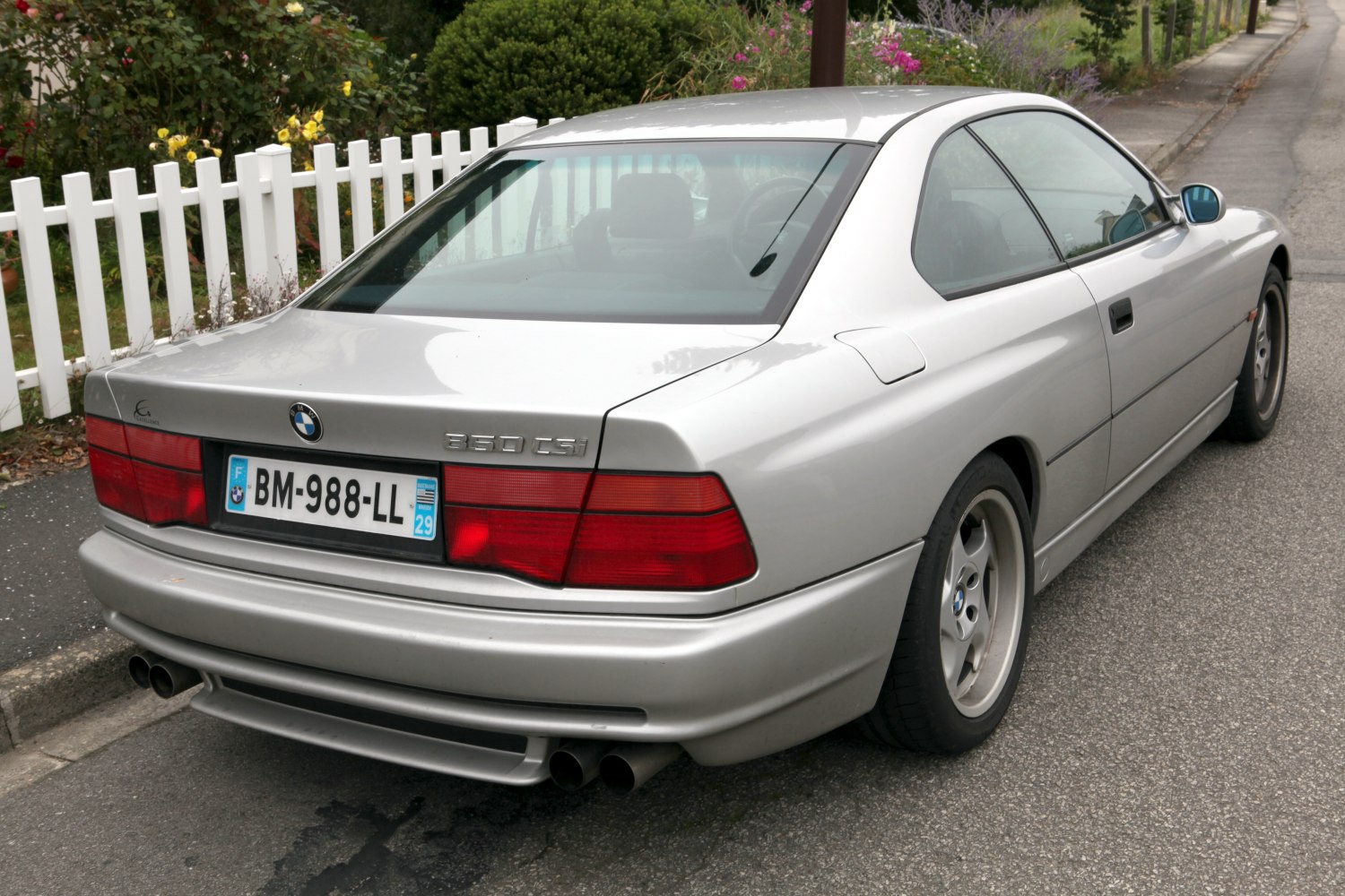 Rear and side view of coupe with distinct taillights and dual exhausts