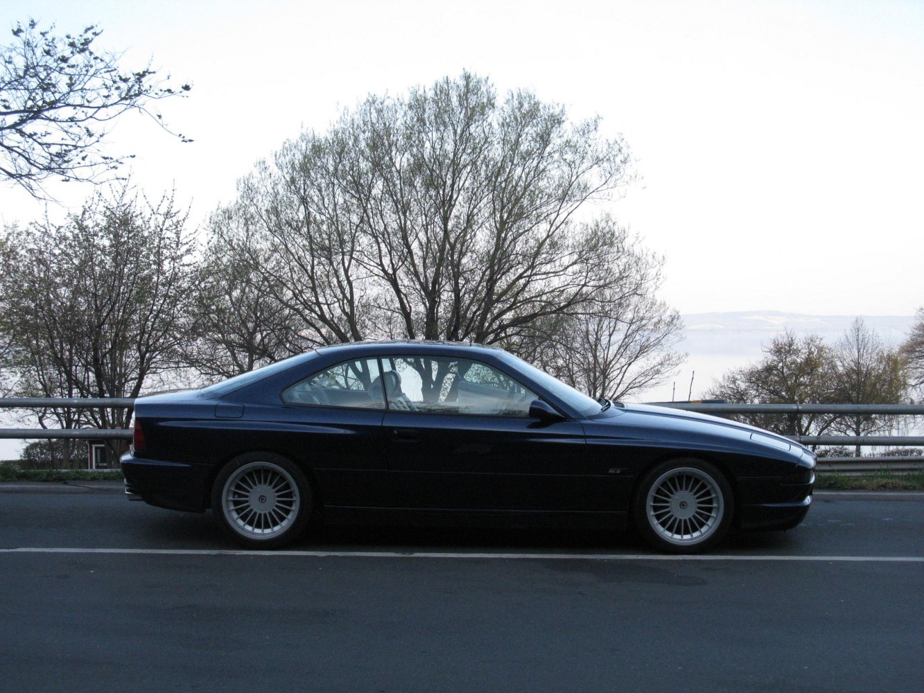 Sleek side profile of a classic coupe with distinctive alloy wheels.