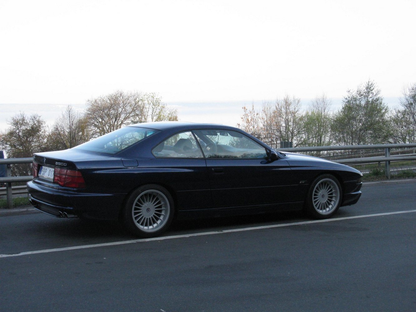 Sleek coupe side profile with fastback roofline and multi-spoke alloy wheels