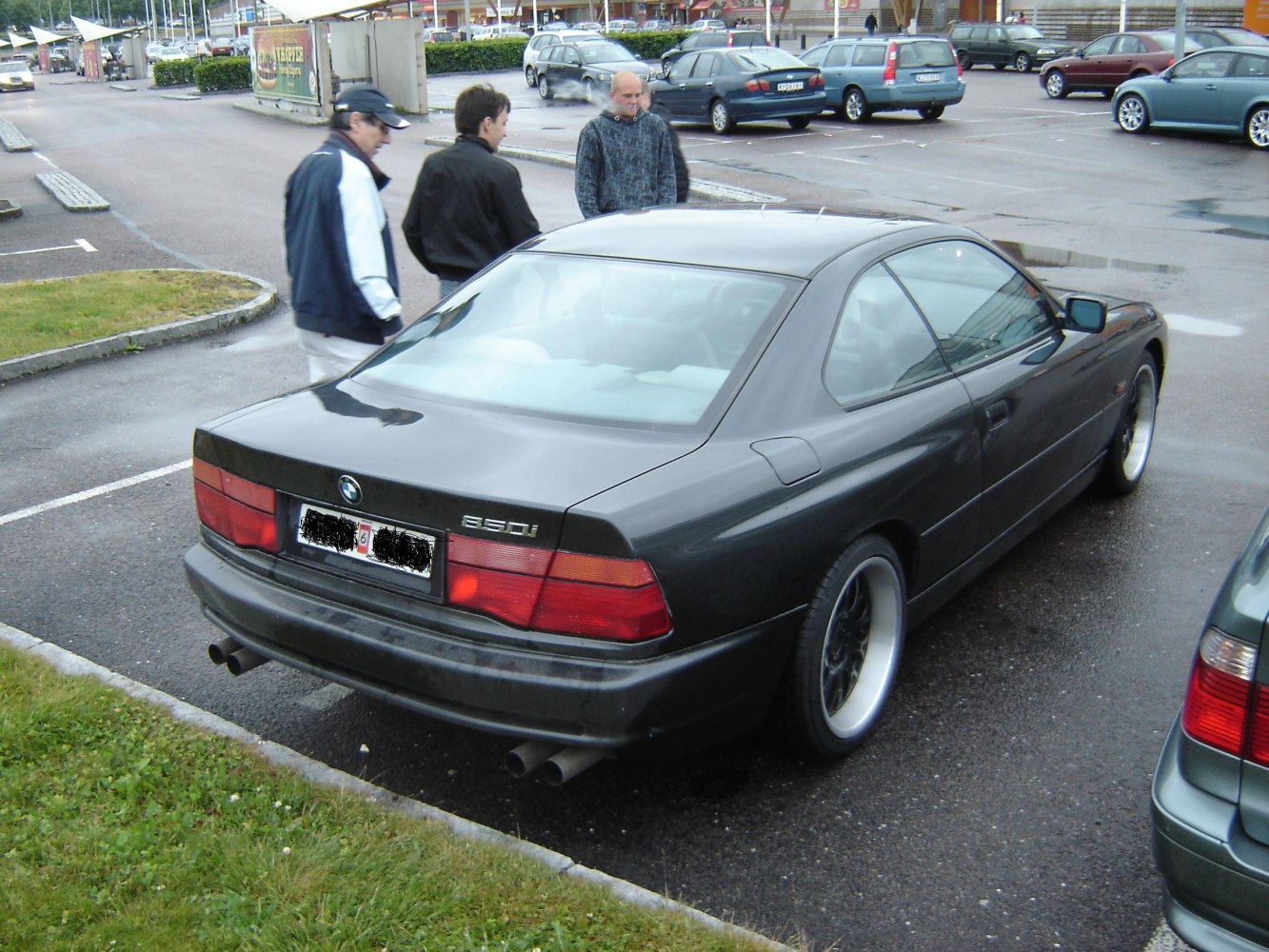 Sporty coupe rear view with dual exhaust pipes and wide alloy wheels
