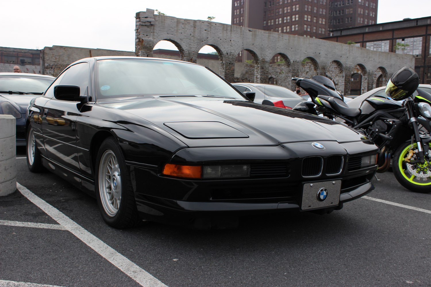 Front view of a black sports coupe with pop-up headlights and kidney grille.