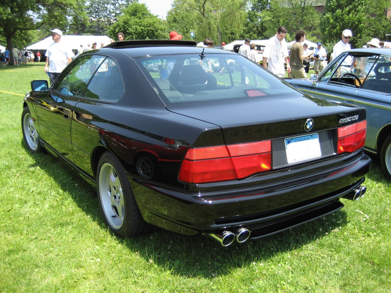 Rear view of a black coupe with quad exhaust and wide red taillights.