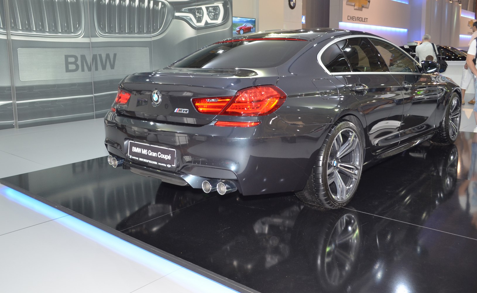 Rear and side profile of a luxury performance coupe with quad exhaust and sporty wheels