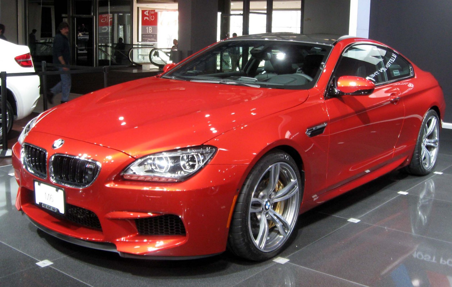 Red sports coupe with aggressive front and large gold-caliper alloy wheels