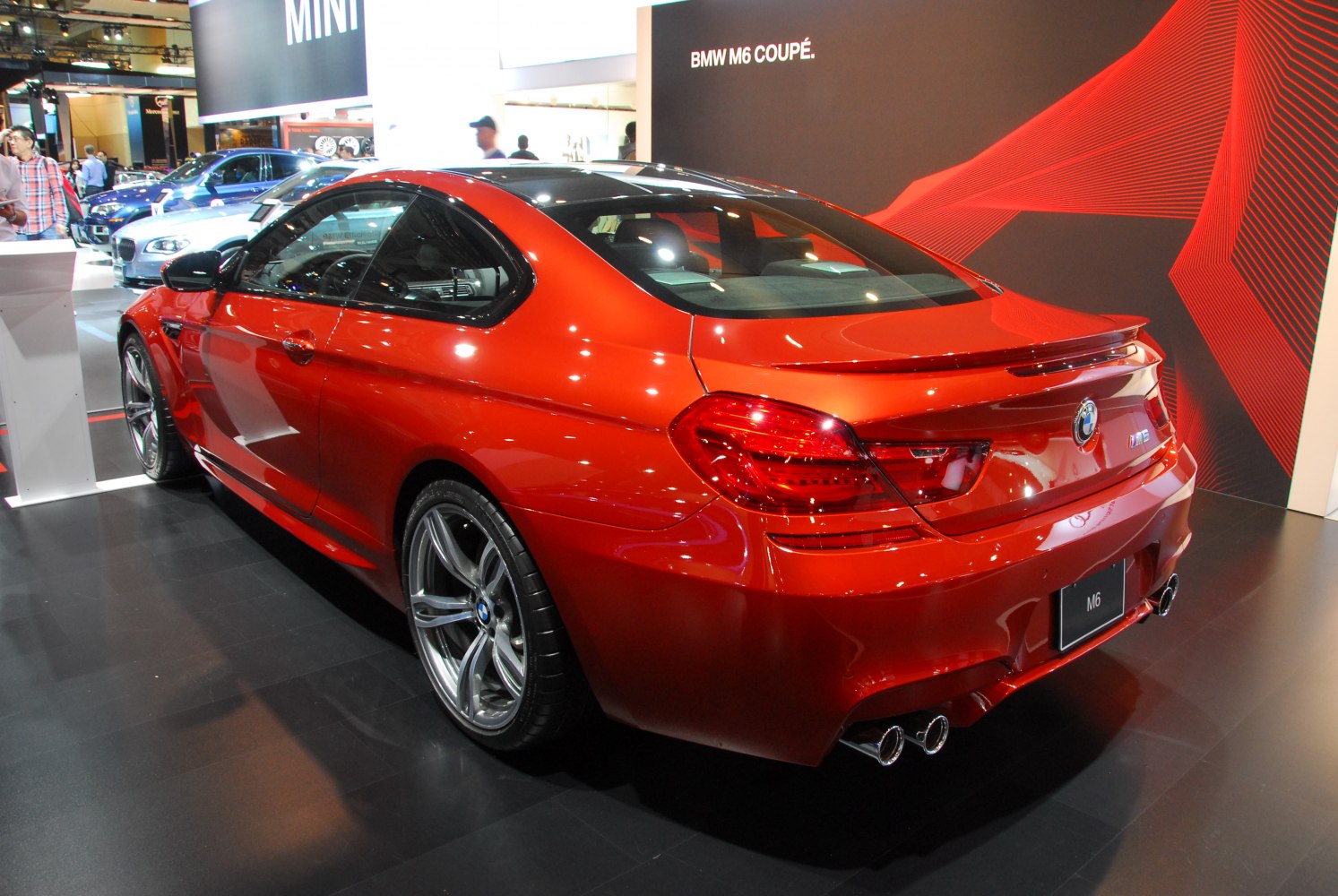 Rear and side view of red luxury coupe with quad exhaust and alloy wheels