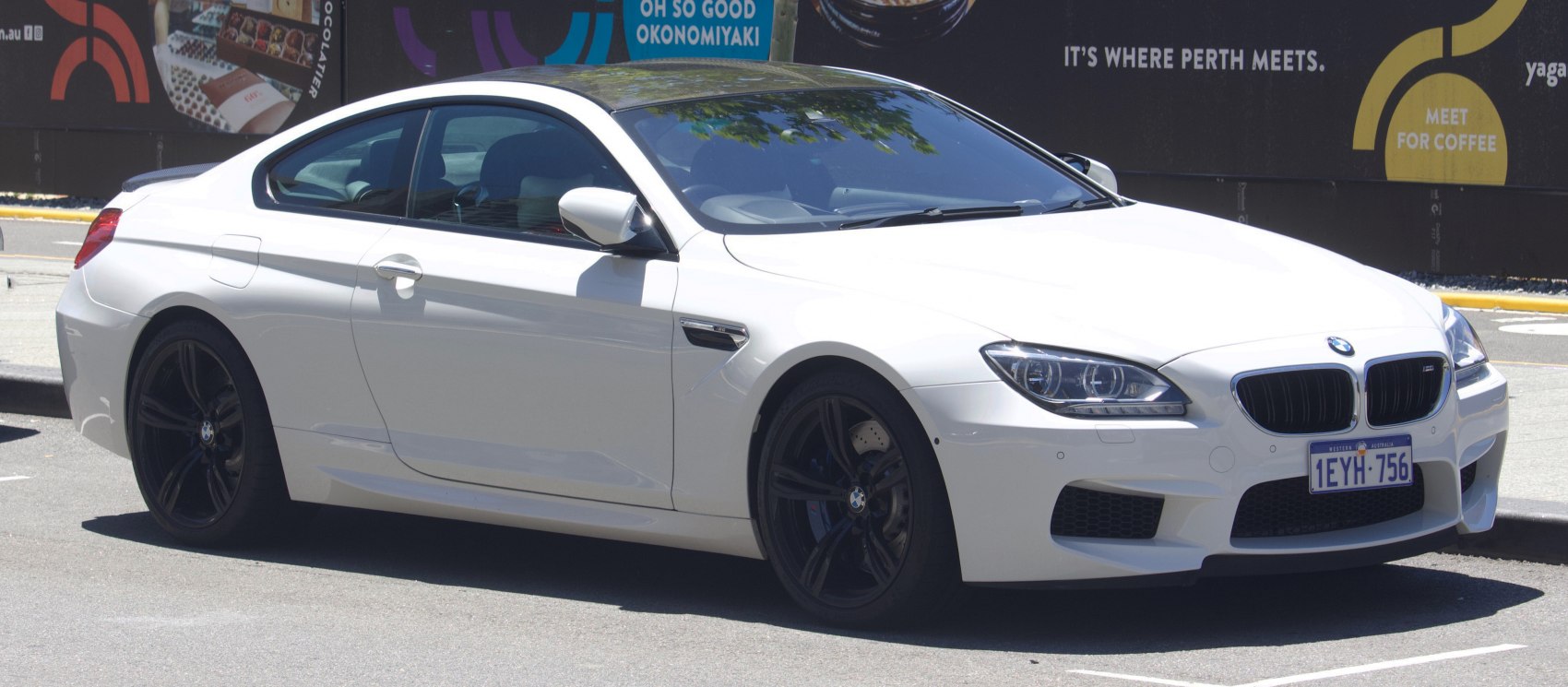 Front side view of sleek coupe with black alloy wheels and performance styling