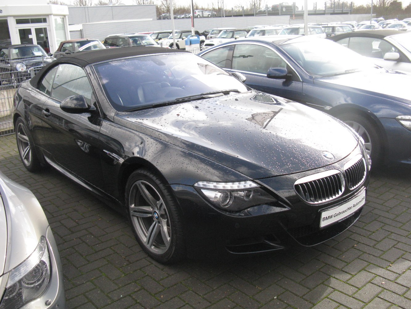 Black convertible with closed soft top and LED headlights