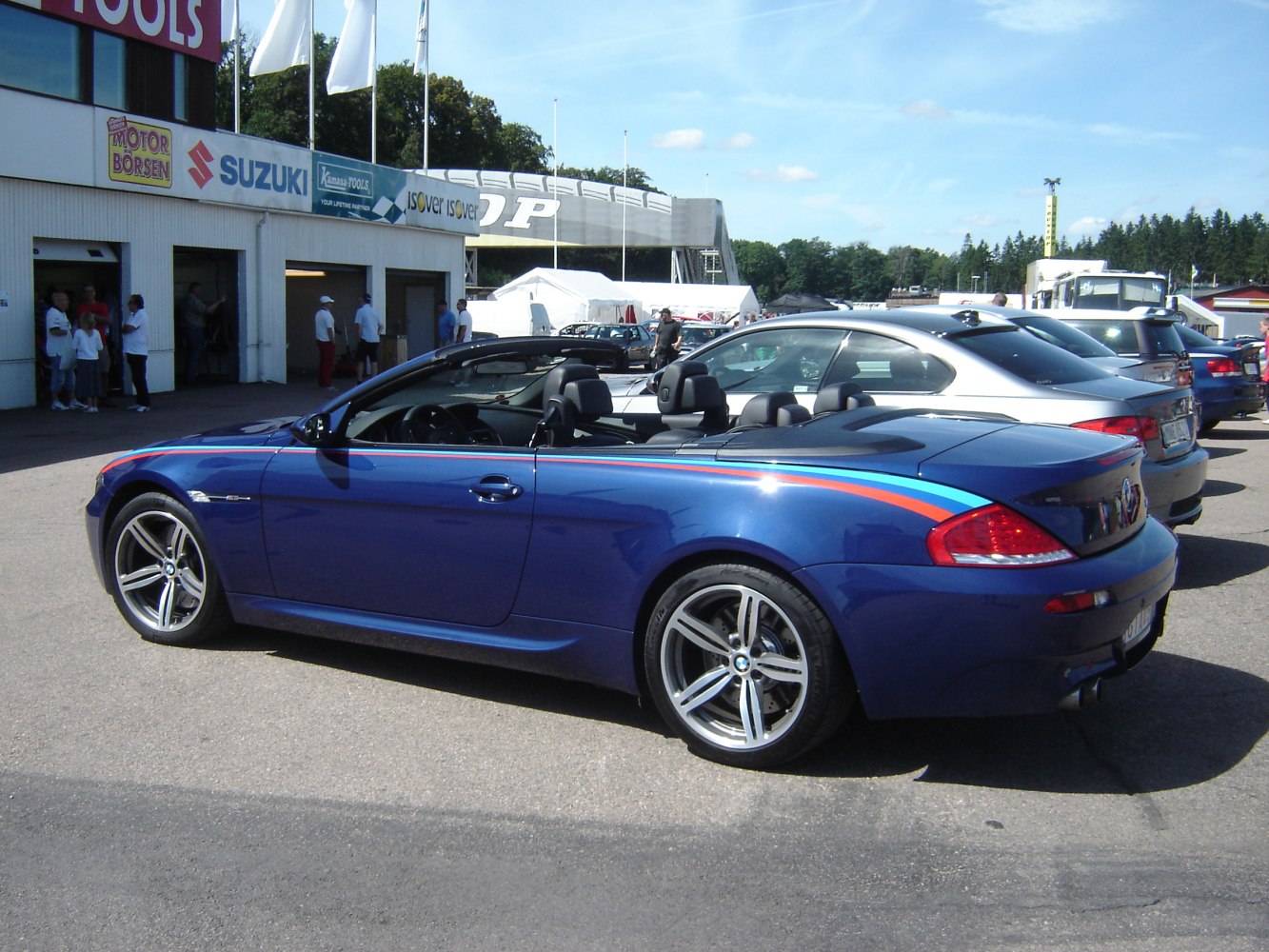 Blue convertible with sporty stripes, 5-spoke alloy wheels, and open roof