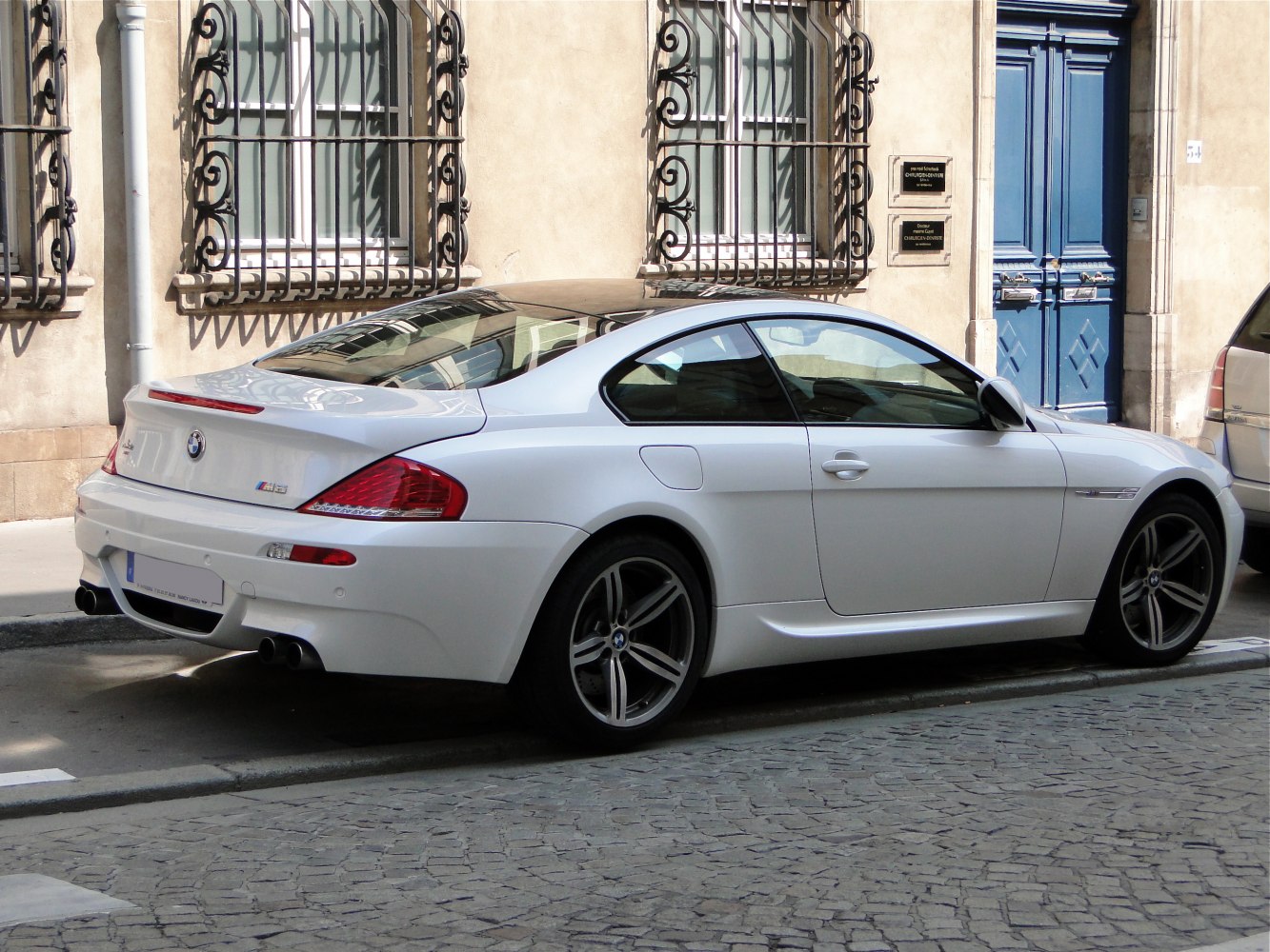 White coupe rear and side profile with distinctive rear lights and alloy wheels