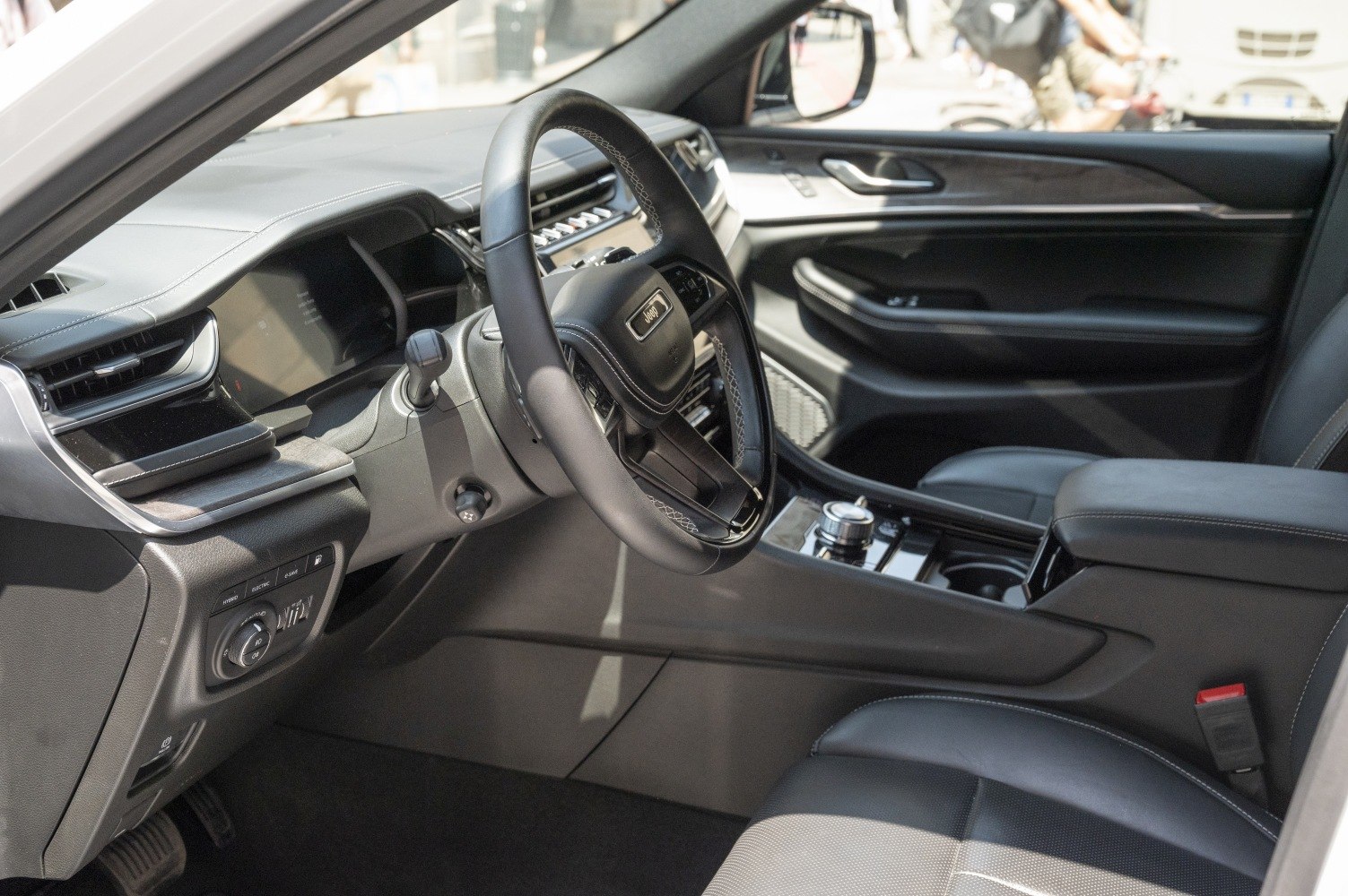 Luxury dashboard and advanced steering wheel controls in black leather interior.
