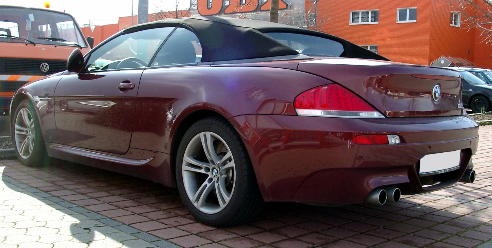 Rear view of convertible with soft fabric roof and quad exhaust pipes
