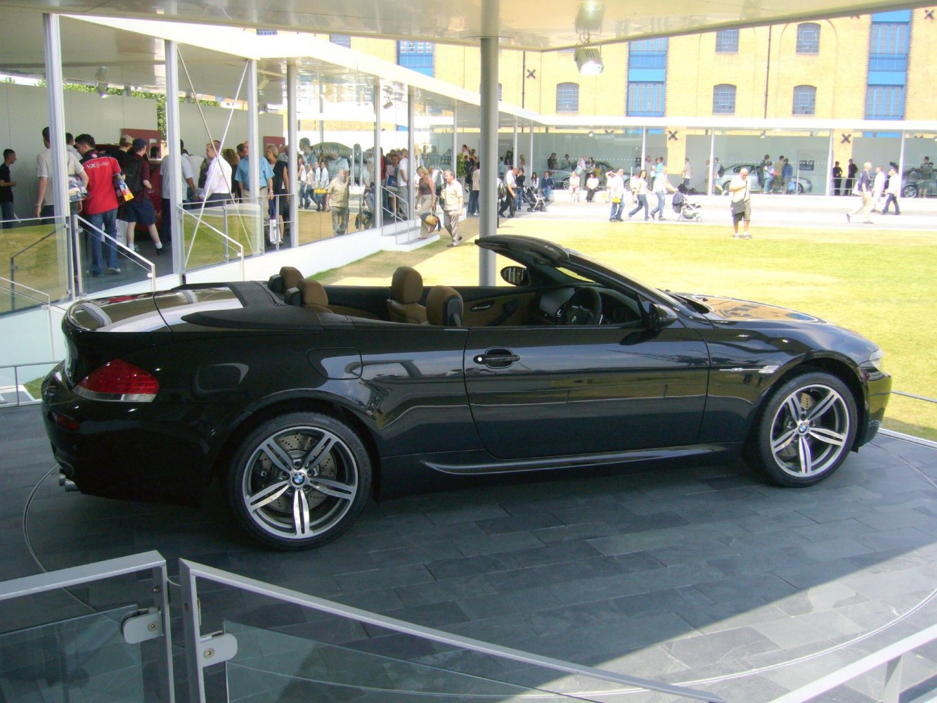 Black convertible with alloy wheels and open roof, side profile