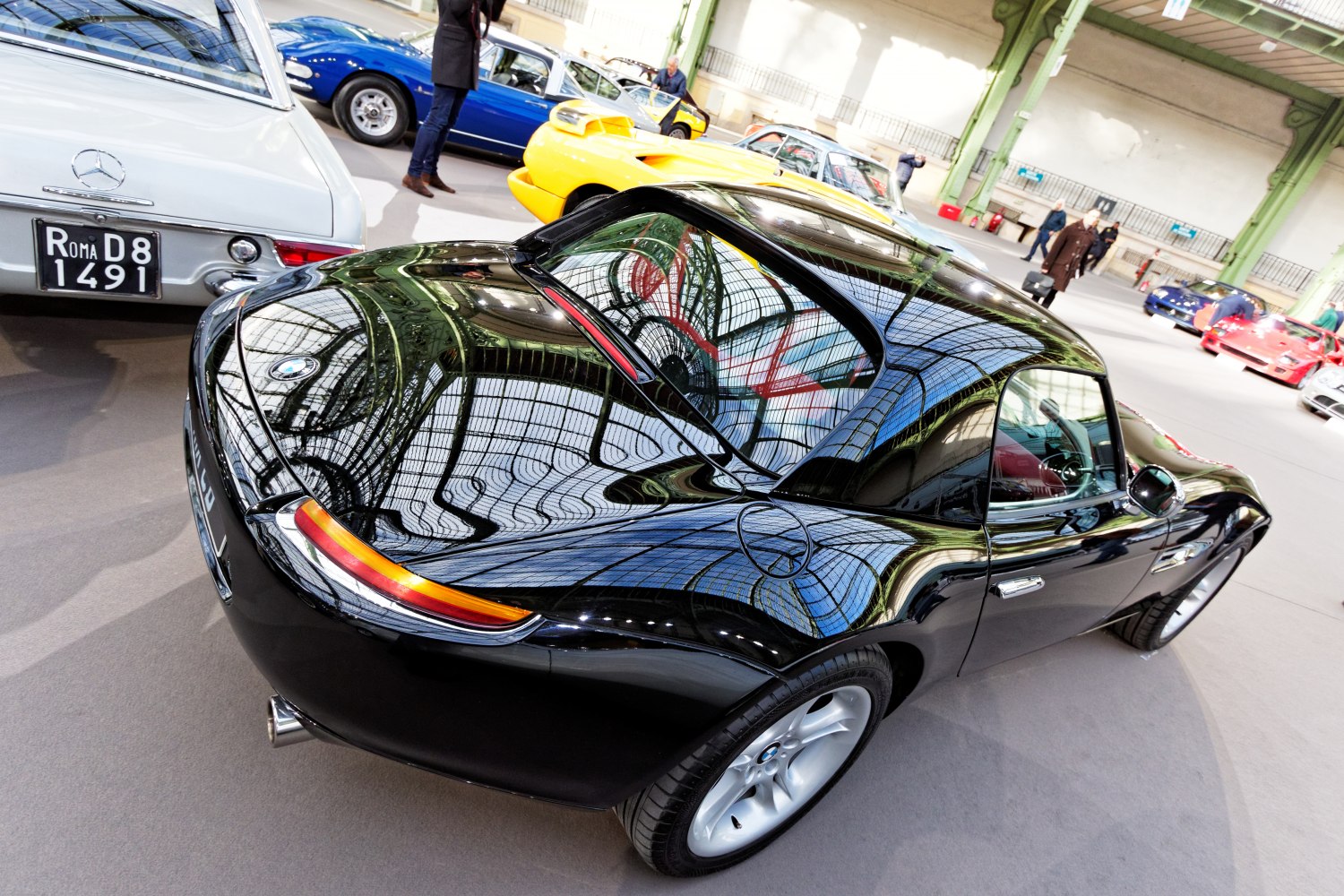 Glossy black sports coupe rear view with aerodynamic curves and reflective surface