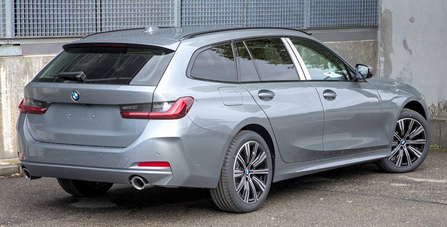 Rear view of a silver estate with dual exhaust and modern taillights