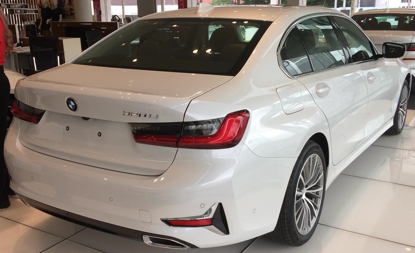 Rear view of white luxury sedan with sleek taillights and sporty bumper