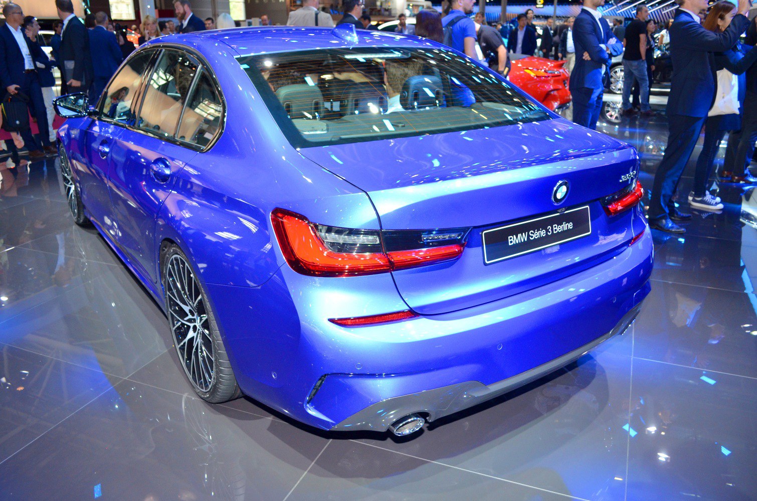 Rear view of a blue sedan with sporty tail lights and dual exhaust tip.