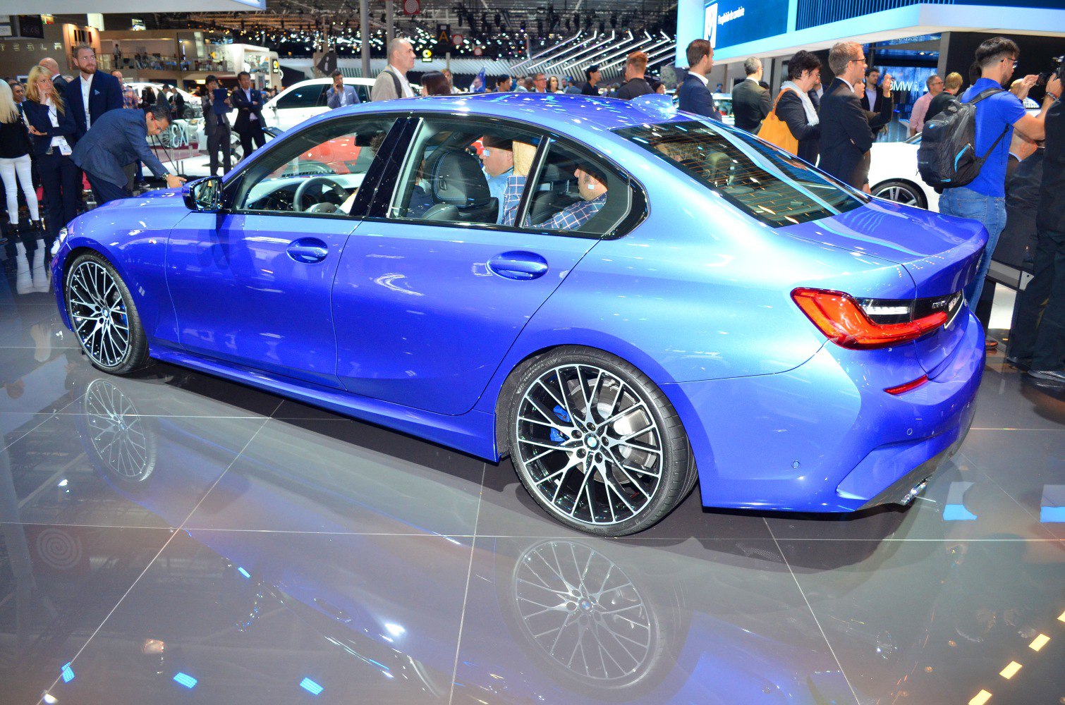 Sporty blue four-door sedan with multi-spoke alloy wheels.
