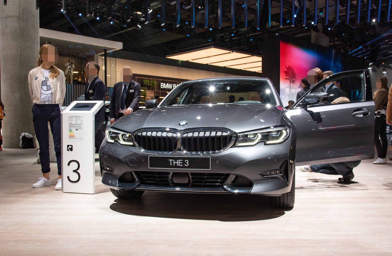 Front view of sedan with illuminated LED headlights and prominent grille