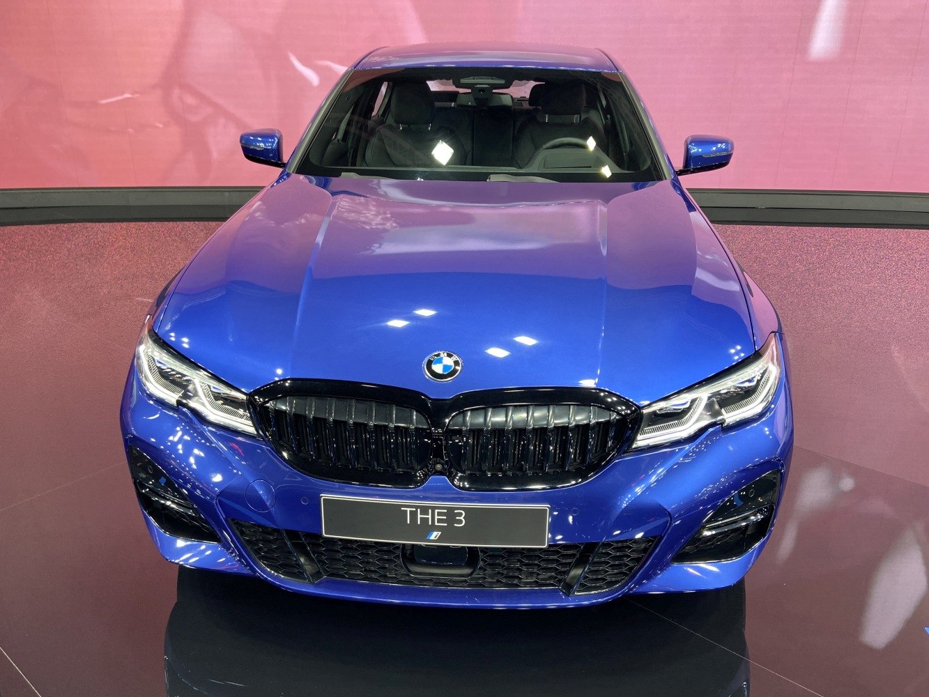 Front view of blue car with black kidney grille and sharp LED headlights