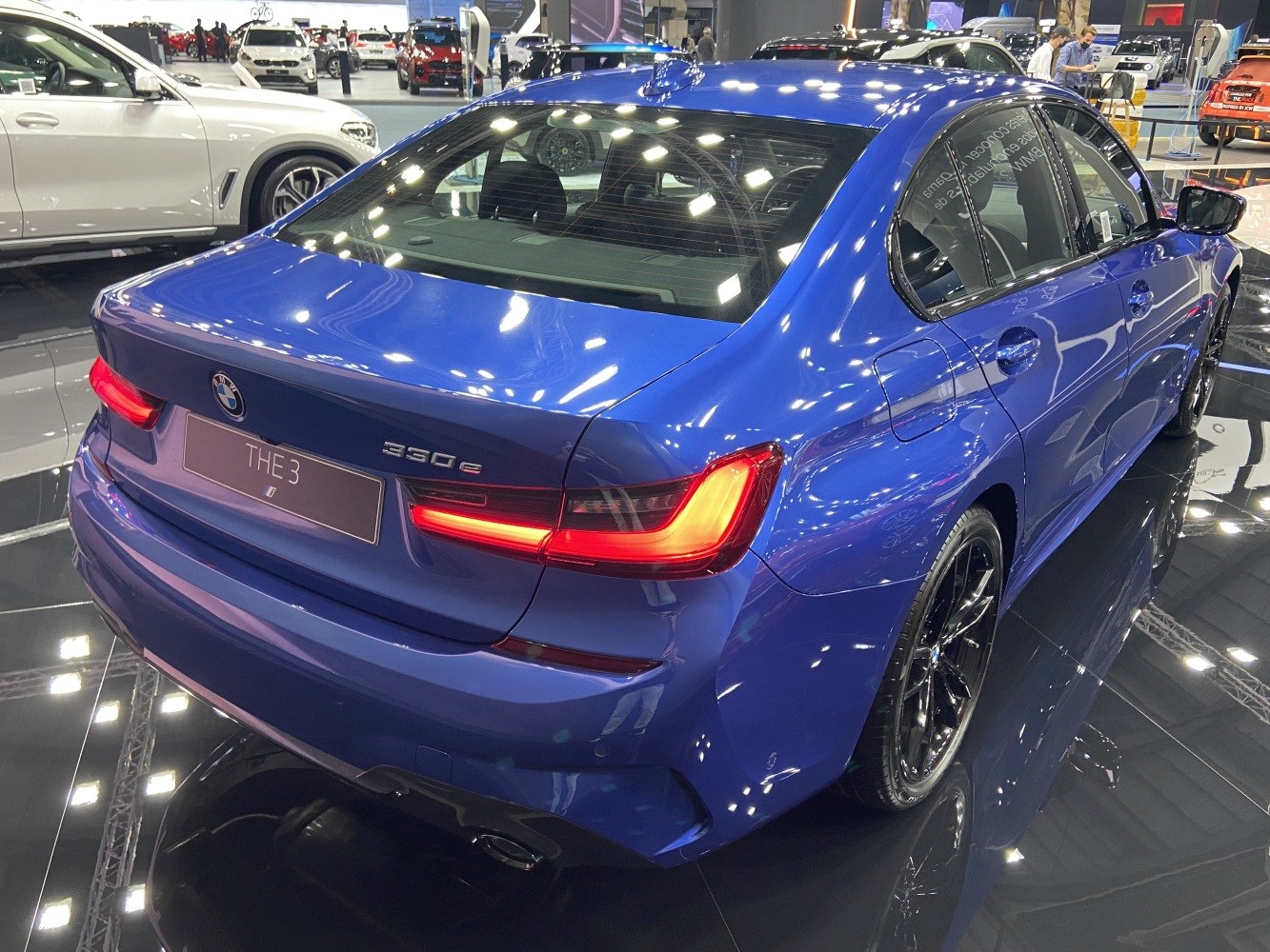 Rear view showing LED taillights and blue sedan body