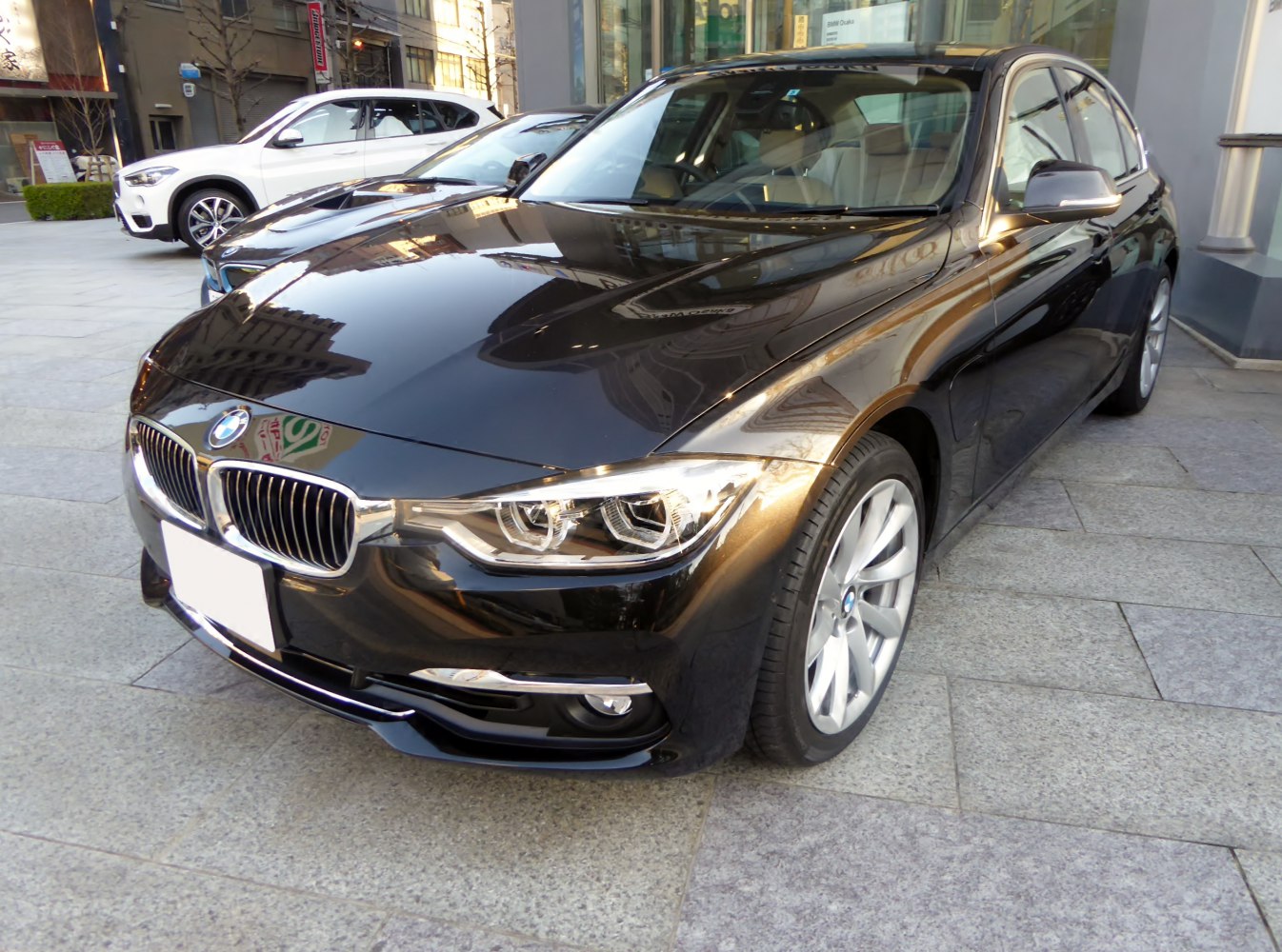 Modern sedan front with detailed headlights and alloy wheels