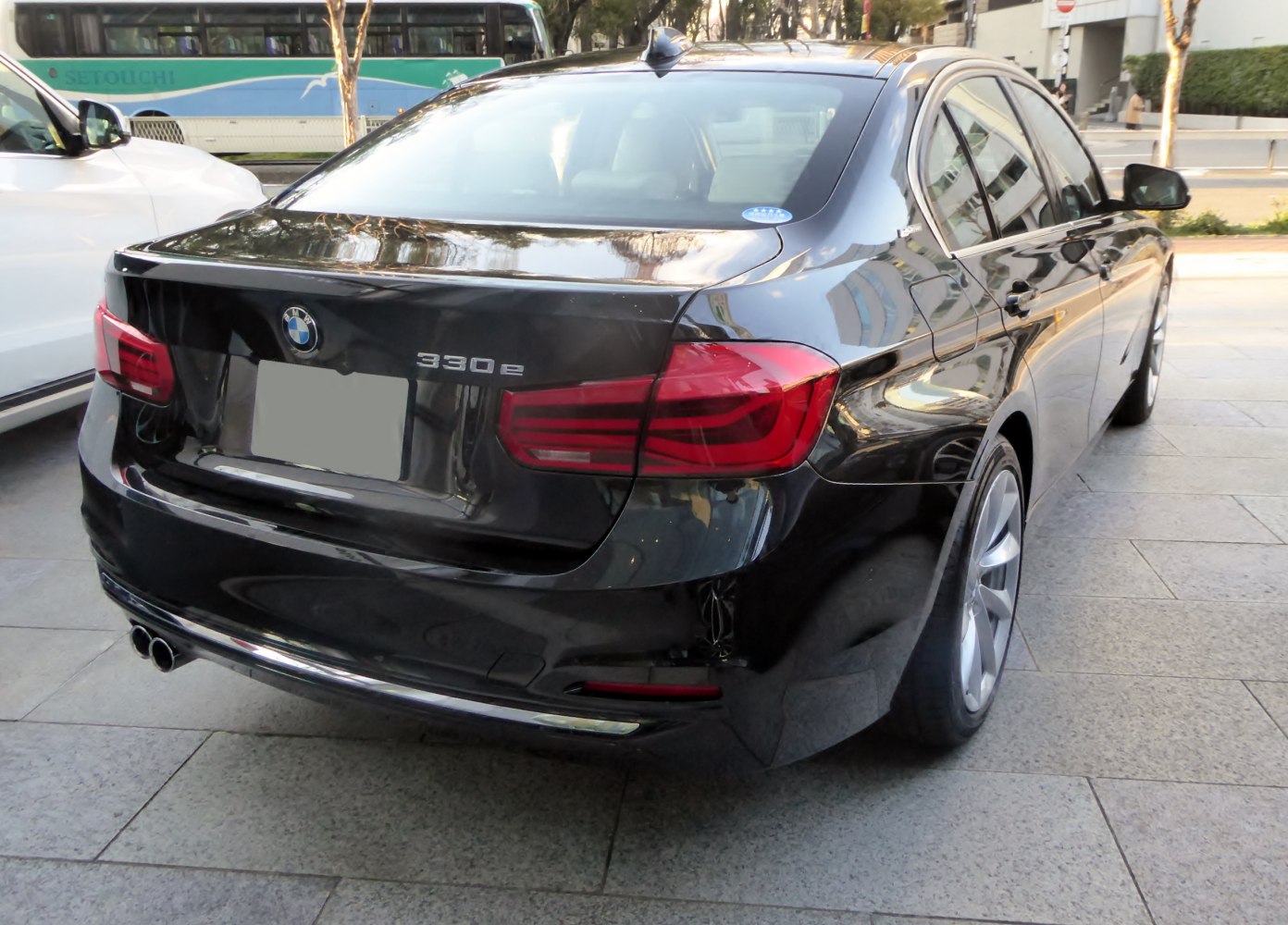 Black BMW 3 Series Sedan rear with 330e badge, tail lights, dual exhausts