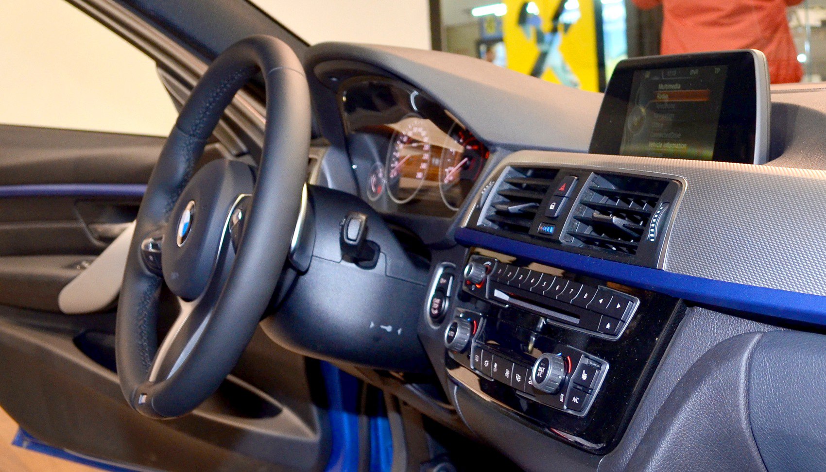 Steering wheel, dashboard controls, and infotainment screen inside car