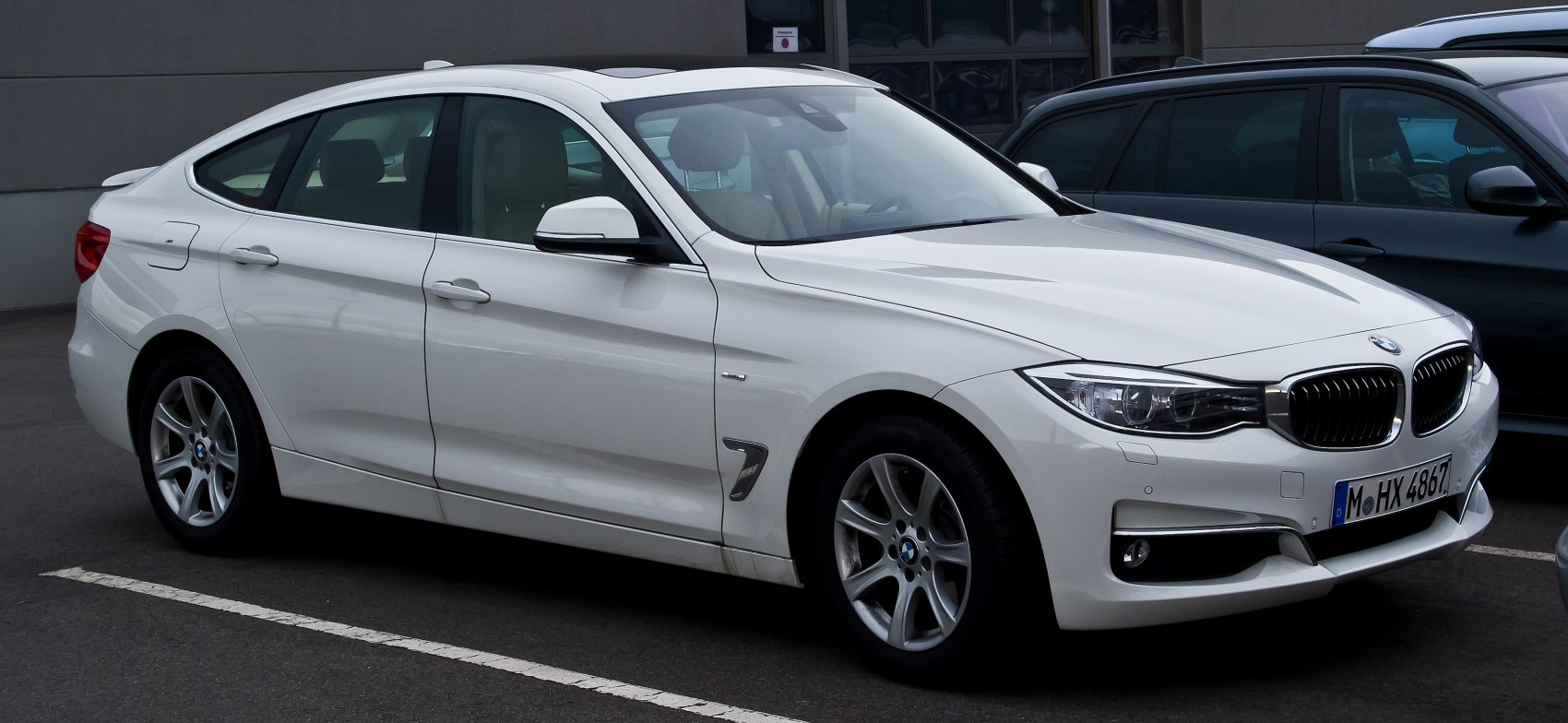White four-door sleek luxury sedan with sporty design and alloy wheels