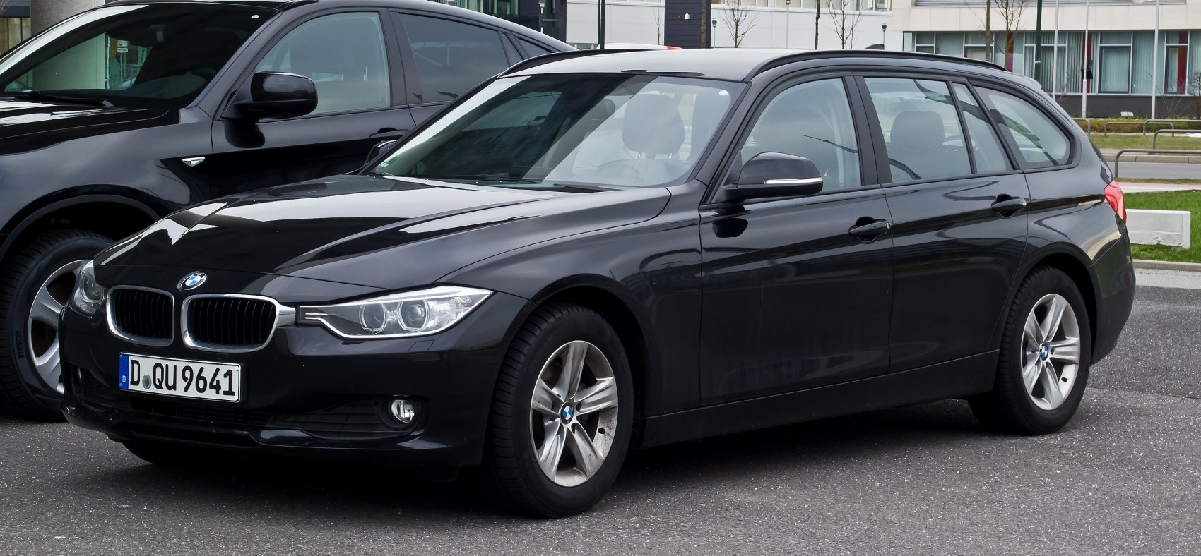 Front-side view of black station wagon with sleek headlights and alloy wheels