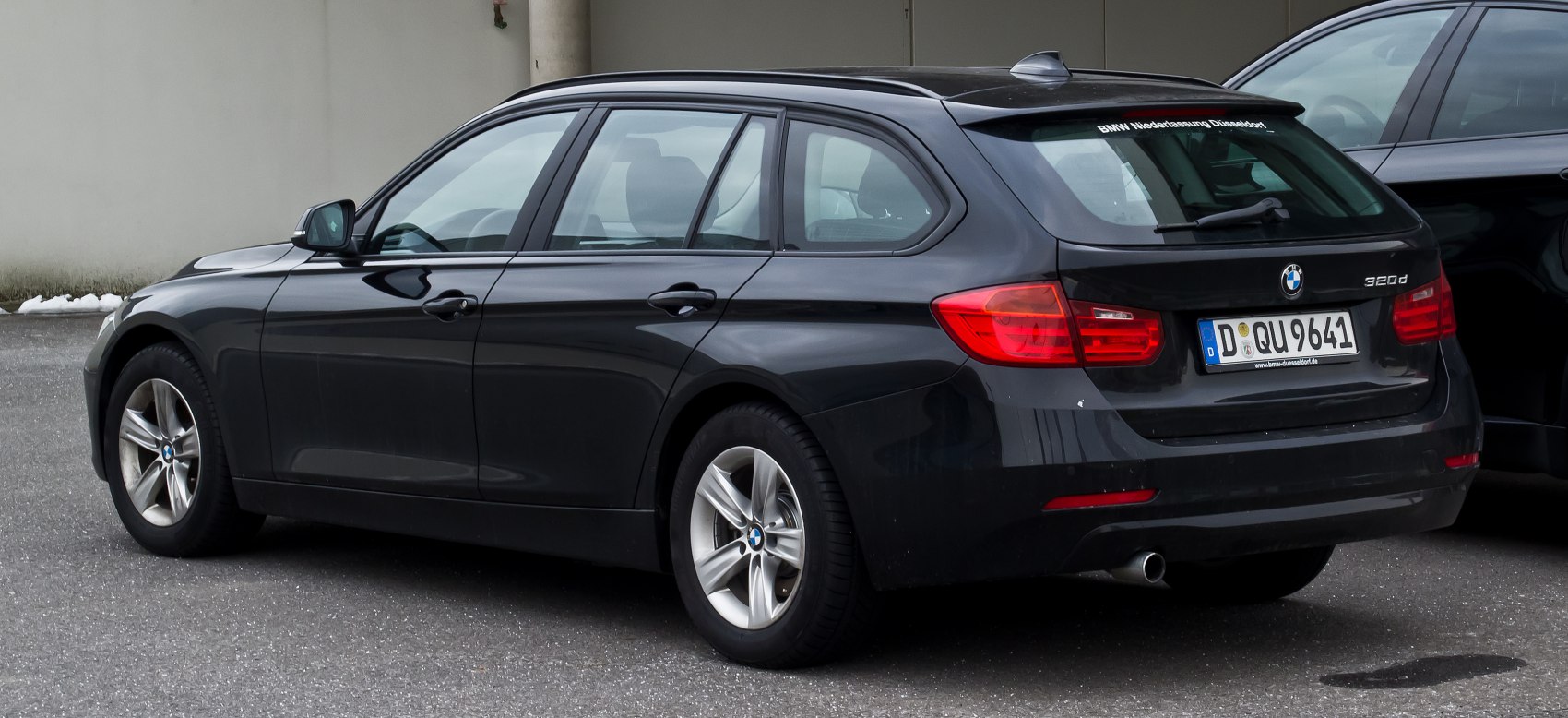 Rear side profile of black 3 Series Touring wagon with distinct taillights